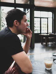 portrait of young handsome caucasian male sitting in cafe