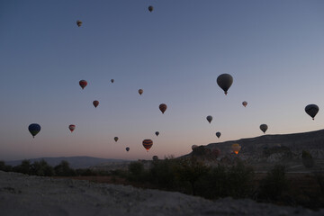 Hot air balloons flying over Cappadocia. Famous tourists destination. Travel to Turkey.