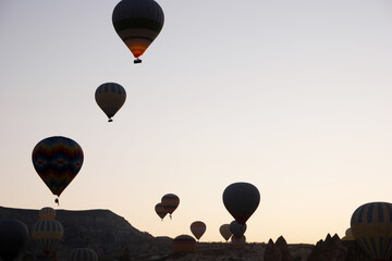 Silhouettes of hot air balloons on sky background. Goreme, Cappadocia, Turkey.