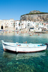 Fototapeta na wymiar Characteristic view of the coastal city of Cefalù near Palermo in Sicily. It has a cristal clear blue water and nice old houses in front of the sea 