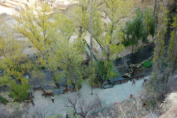 Top view of road, river and green trees in turkish city. People walking on the street. Cappadocia, Turkey.
