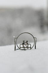 Two figures sitting on a metal bench in the snow
