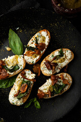 Bruschetta with cheese and mushrooms and pasta pesto and basil on a plate