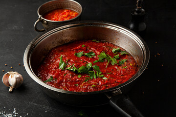 Tomato sauce with onions and garlic and basil in a pan