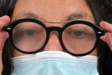 Femme portant un masque avec de la buée sur les lunettes - obrazy, fototapety, plakaty