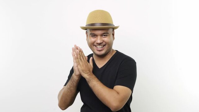 Wily Guy put on hat in casual clothes rubbing hands with crafty eyes on isolated white background. 4K Resolution.