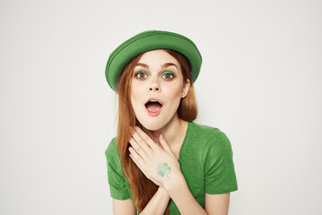 happy woman in green clothes in st patricks day shamrock hat makeup model