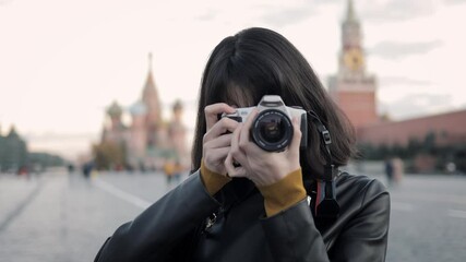 Young woman photographer at the centre of Red Square in Moscow. Happy young asian woman tourist taking pictures looking at the camera, closeup handheld shot - Powered by Adobe
