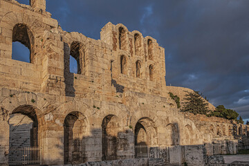 Fototapeta na wymiar Picturesque view of Greek ruins of Odeon of Herodes Atticus (161AD) - stone Roman theater at the Acropolis hill on sunset. Athens, Greece.