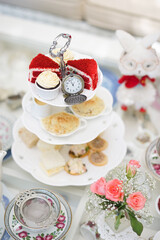 Afternoon tea. A set of afternoon tea for two. High tea with soft focus on the cupcake on the top  tier cake stand.
