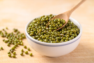 Mung bean with spoon in a bowl on wooden background