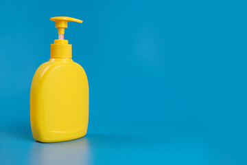 Yellow bottle with dispenser for soap, shampoo or antiseptic. Space for text