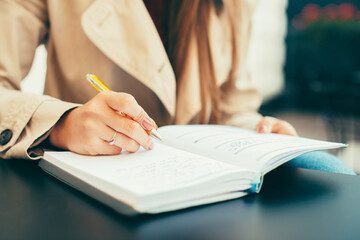 A woman writting in her planner at a table .
