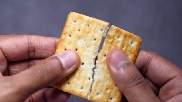  man's hand breaking a biscuits 