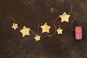 
Garland of homemade shortbread star shape sugar cookies. Christmas mood theme.