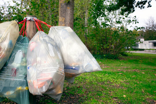 garbage bag for plastic hanging in the street for pick up garbage collector, waiting to destroy. Recycle and environment concept