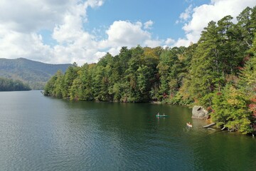 Aerial view of three young women canoeing and kayaking on Lake Santeetlah, North Carolina in autumn.