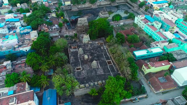 aerial view of There is an old Hindu temple in the middle of beautiful trees and houses, and the temple pond is being cleaned