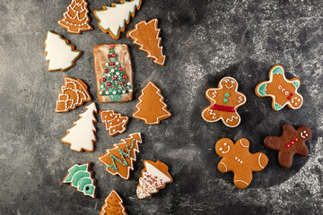 Various christmas gingerbread cookies on dark table with flour