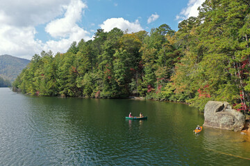 Aerial view of three young women canoeing and kayaking on Lake Santeetlah, North Carolina in autumn.