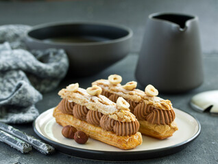 Homemade eclair with chocolate and nuts. Pastry.