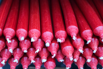 Stacks of candles with selective focus in a shelf shown in a small store.