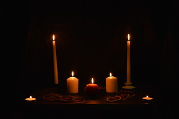 Group of burning candles on black background.