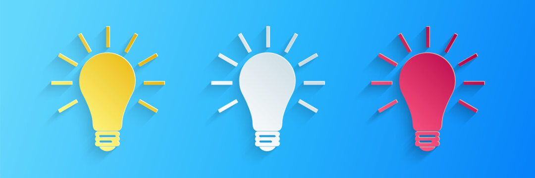 Paper cut Light bulb with rays shine icon isolated on blue background. Energy and idea symbol. Lamp electric. Paper art style. Vector.