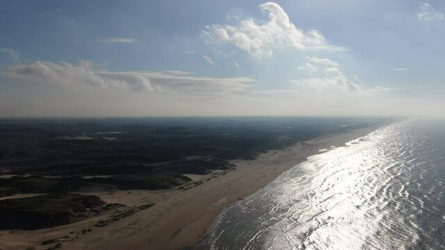 Cinematic 4k aerial video of the Dutch coastal dunes and north sea beach on a sunny day