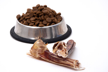 Dog treats and dry feed in bowl on white background with copy space. Variety of dog treats. flat lay