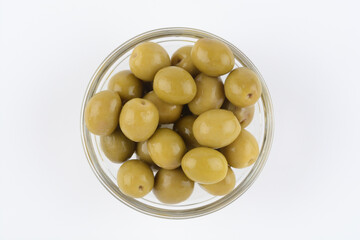 Aceitunas verdes con hueso en un bol de cristal, vista desde arriba