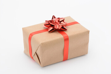 Caja de regalo envuelta con papel marrón y con cinta roja