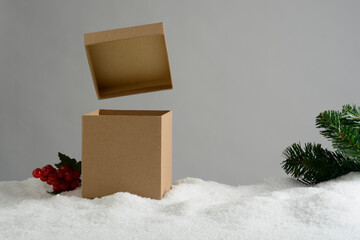Caja de regalos en la nieve con la tapa elevada sobre la caja