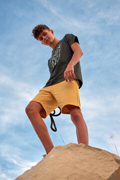 Vertical low angle shot of a Caucasian boy looking at the camera