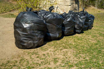 black plastic bags with rubbish in nature