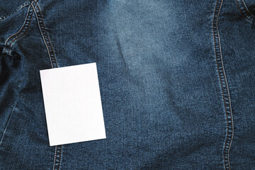  selembar kertas kosong, mockup kartu ucapan dan amplop. Latar belakang blue denim jeans.