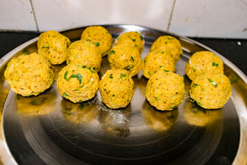  Indian Vegetarian koftas made with bottle gourd and gram flour as a main ingredients with onion, coriander leaf other ready for frying.
- 387812654