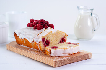 Yogurt gluten free pound cake with raspberries and sugar glaze on a white background