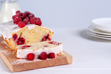 Yogurt gluten free pound cake with raspberries and sugar glaze on a white background