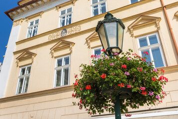 Fototapeta na wymiar Street light with colorful flowers in Litomerice, Czech Republic