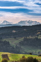 Meadows and Pasture on Rolling Hills with Snow Covered Tatra Mountains in Poland at Fall