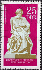 GERMANY, DDR - CIRCA 1970: a postage stamp from Germany, GDR showing the mother home, sculpture of the Soviet memorial in Berlin-Treptow