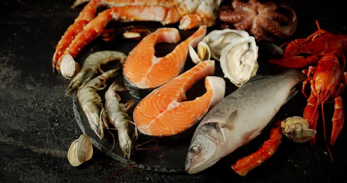 Fish and seafood rotate on a stone board. 