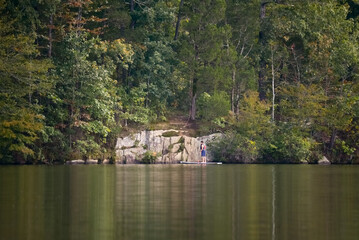 Fototapeta na wymiar Paddleboard on lake by the rocks