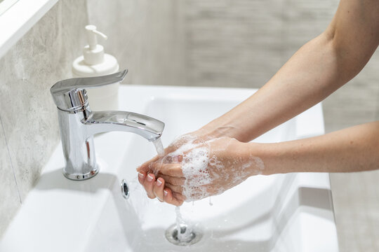 Woman washing her hands in sink at bathroom