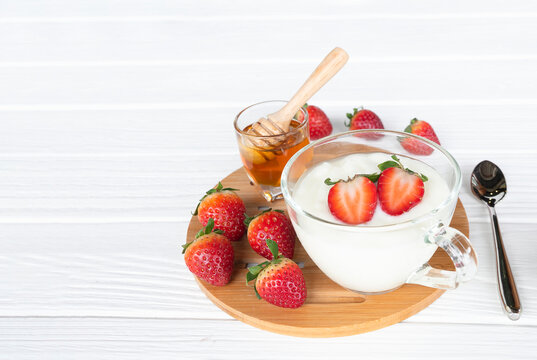 Fruit yogurt has strawberry raspberry blueberry canberry and honey greek white clean In bowl on a wooden background from top view.

