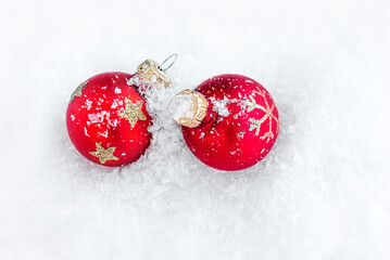 Christmas decorations in the snow with copy space. Xmas Red Baubles top view.