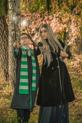Obraz na płótnie Canvas Kid and witch woman in of the magical atmosphere. Boy and mom in green robe magic in the forest. Family Halloween time