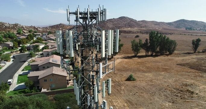 4K Close-up Aerial of Cellular Wireless Mobile Data Tower with Neighborhood Surrounding.