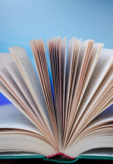 Pages of an unfolded book with a binding on a colorful background